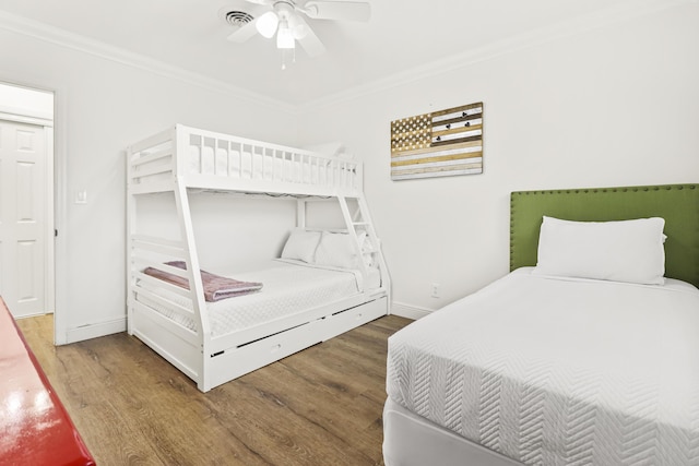 bedroom with crown molding, ceiling fan, and dark hardwood / wood-style flooring