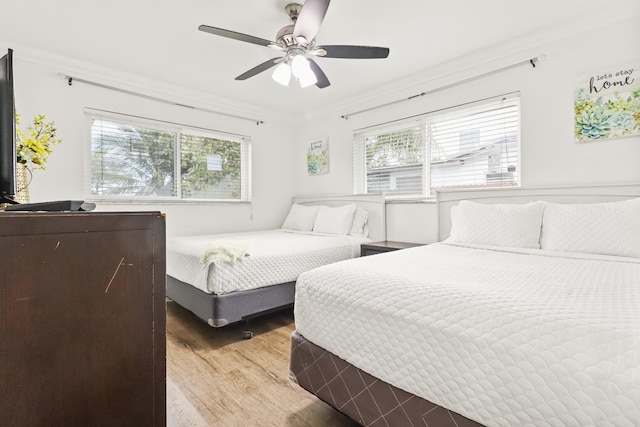 bedroom featuring crown molding, ceiling fan, and light wood-type flooring