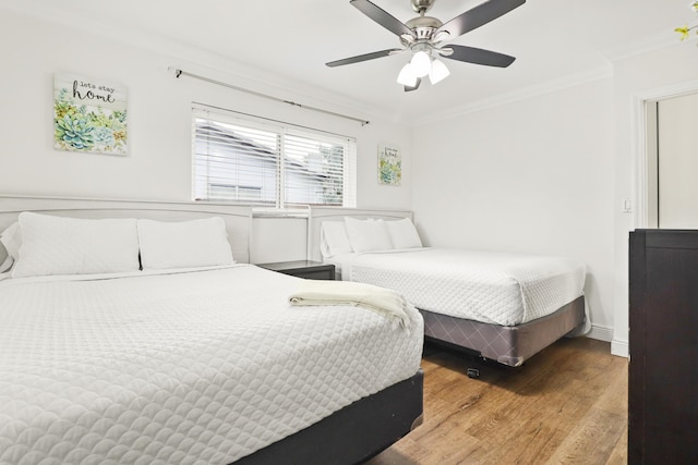 bedroom with crown molding, ceiling fan, and wood-type flooring