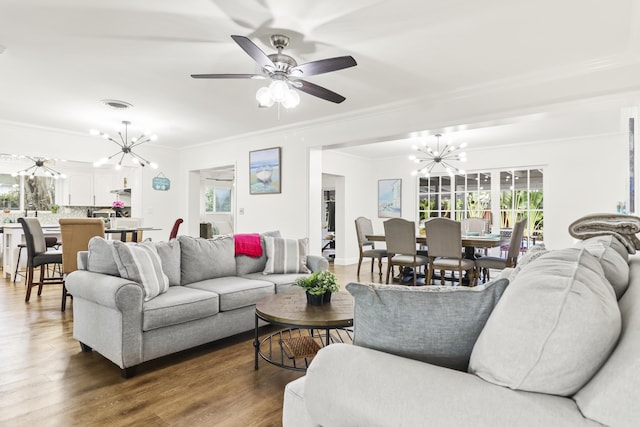 living room with crown molding, hardwood / wood-style flooring, and ceiling fan with notable chandelier