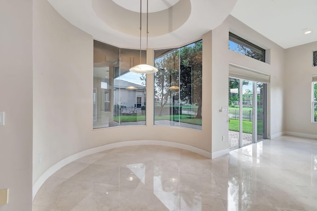 unfurnished dining area with a tray ceiling