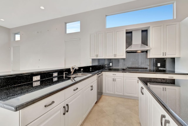 kitchen with white cabinetry, wall chimney range hood, a wealth of natural light, and sink