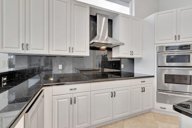 kitchen with light tile patterned floors, white cabinetry, black electric cooktop, wall chimney exhaust hood, and stainless steel double oven