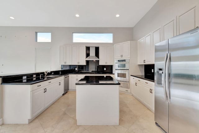 kitchen with wall chimney exhaust hood, sink, a center island, white cabinetry, and appliances with stainless steel finishes