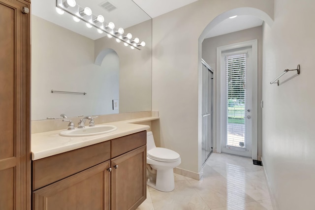 bathroom with toilet, an enclosed shower, vanity, and tile patterned flooring