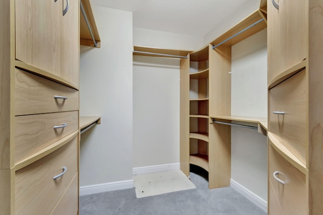 spacious closet with built in desk and light colored carpet