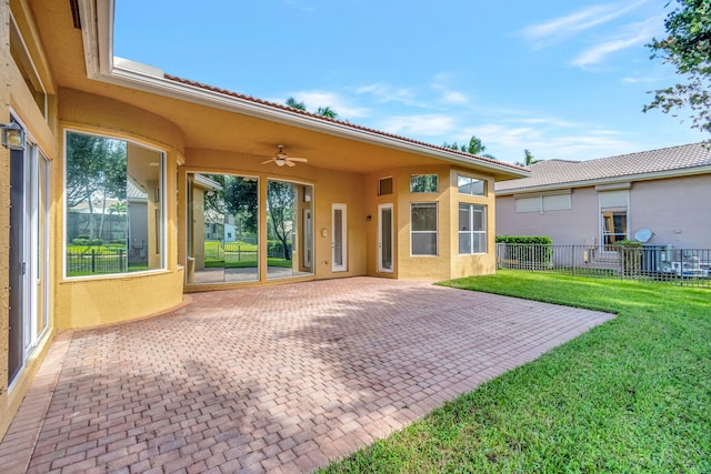 back of house featuring a patio area, a lawn, and ceiling fan