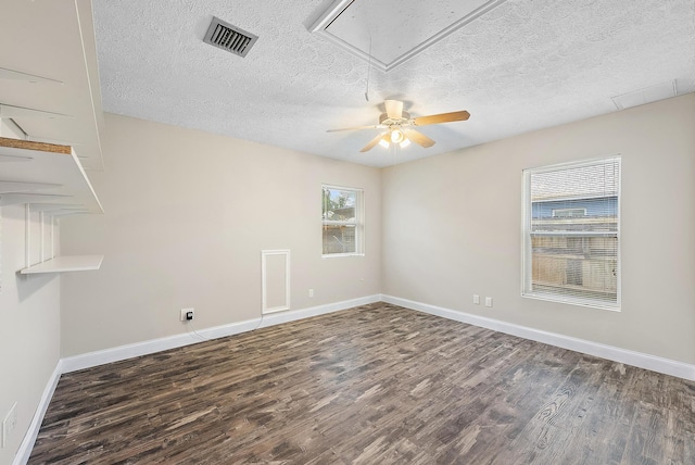 empty room with ceiling fan, a textured ceiling, and dark hardwood / wood-style flooring