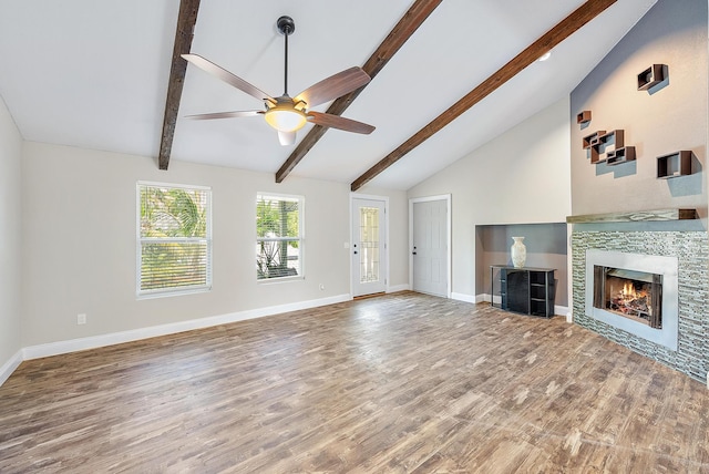 unfurnished living room with ceiling fan, hardwood / wood-style flooring, beamed ceiling, and a tile fireplace