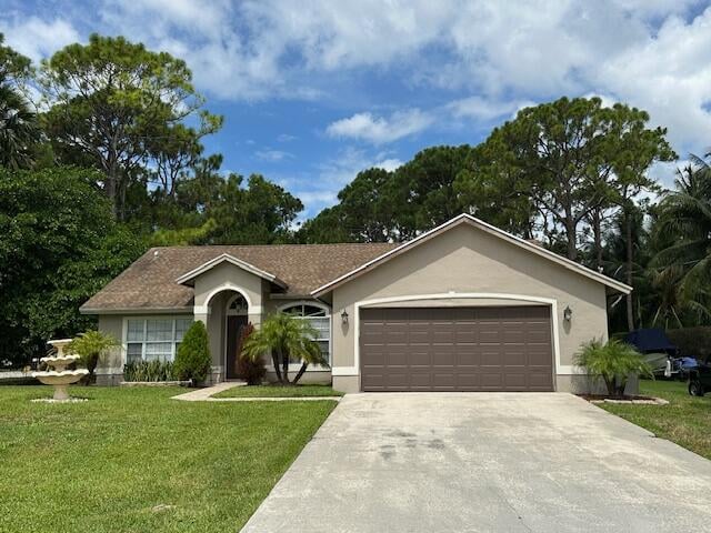 ranch-style home featuring a front yard and a garage