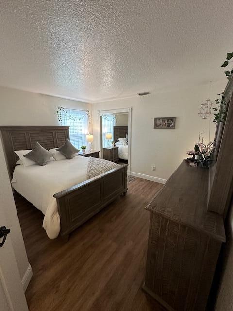 bedroom featuring dark wood-type flooring and a textured ceiling