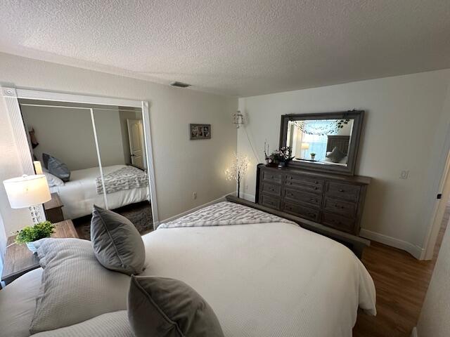 bedroom featuring a closet, a textured ceiling, and hardwood / wood-style floors