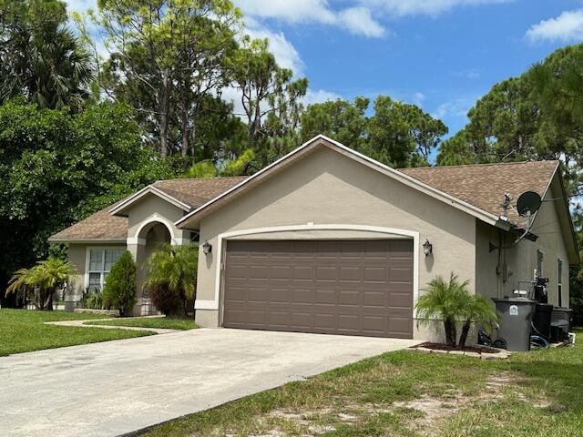 ranch-style home with a front lawn and a garage