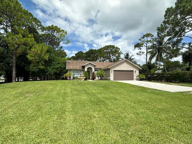 ranch-style home with a front yard and a garage