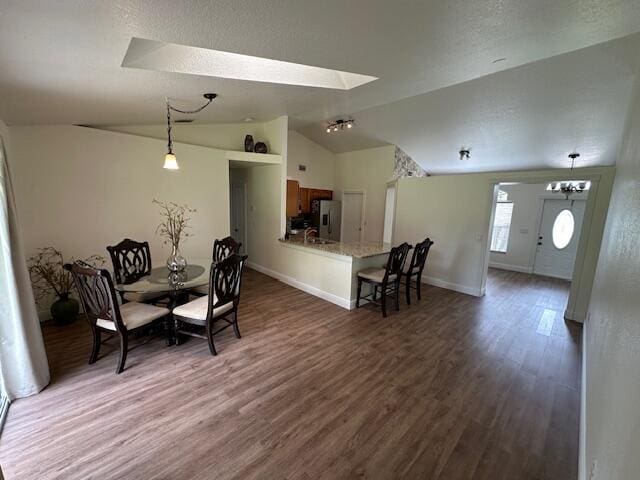 dining area with lofted ceiling, dark wood-type flooring, and sink