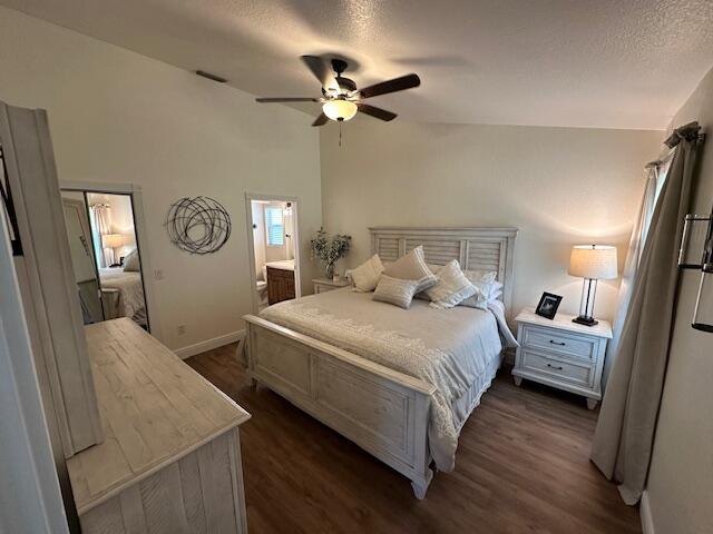 bedroom featuring ceiling fan, dark hardwood / wood-style floors, lofted ceiling, and ensuite bathroom