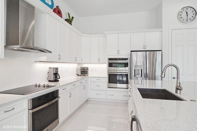 kitchen featuring white cabinetry, sink, stainless steel appliances, and wall chimney exhaust hood