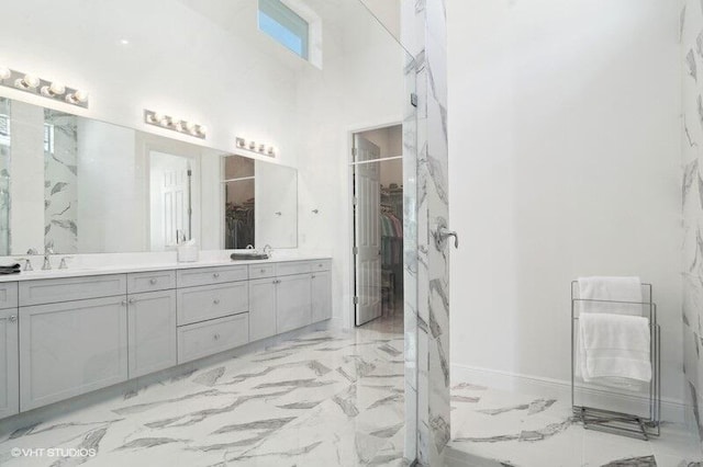 bathroom featuring a high ceiling and vanity