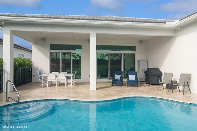 view of pool featuring a grill and a patio area