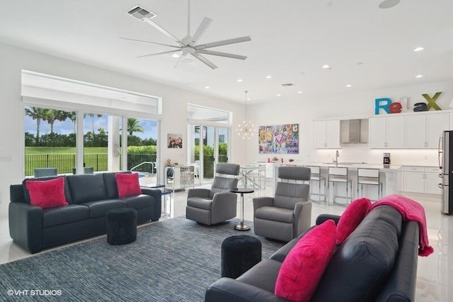 living room with sink and ceiling fan with notable chandelier