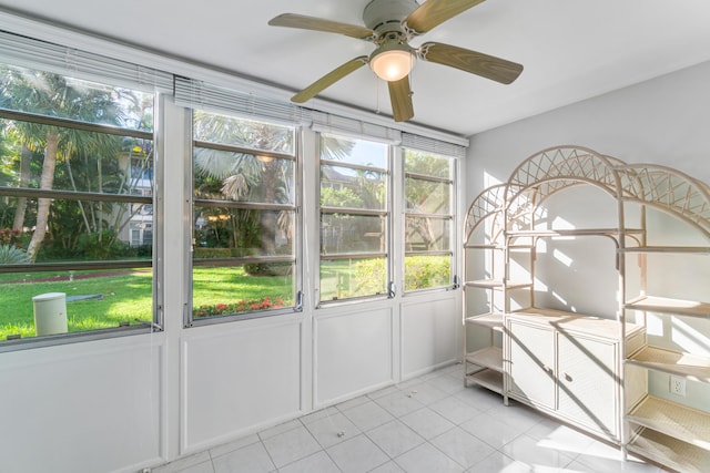 unfurnished sunroom with ceiling fan