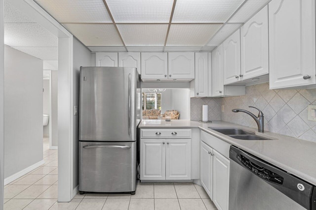 kitchen with light tile patterned flooring, white cabinetry, stainless steel appliances, and sink