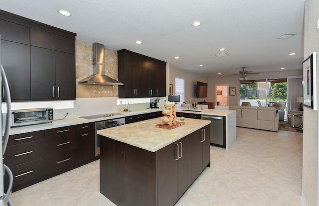 kitchen with dark brown cabinetry, stainless steel appliances, wall chimney range hood, and a center island