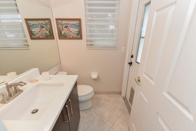 bathroom with toilet, vanity, and tile patterned floors