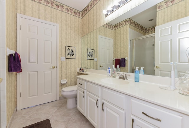 bathroom with a shower with door, vanity, toilet, and tile patterned flooring