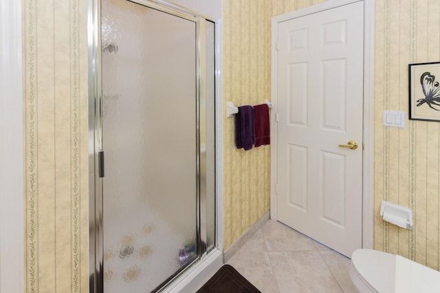 bathroom featuring tile patterned flooring, toilet, and walk in shower