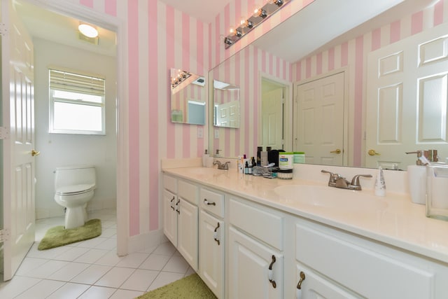 bathroom with toilet, vanity, and tile patterned flooring