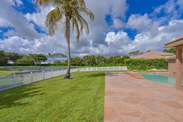 view of yard with a water view, a patio area, and a fenced in pool