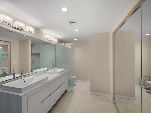 bathroom featuring tile patterned flooring, vanity, toilet, and walk in shower