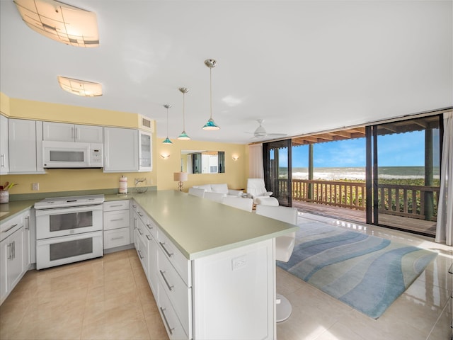 kitchen with pendant lighting, white appliances, ceiling fan, light tile patterned flooring, and kitchen peninsula