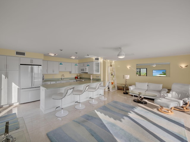 tiled living room with ceiling fan and sink