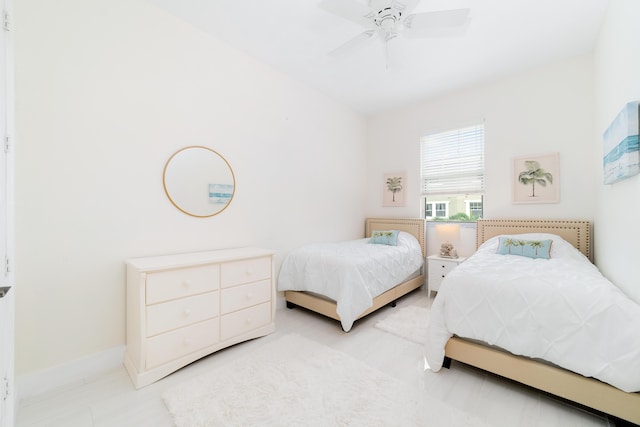 bedroom with a ceiling fan and baseboards