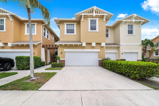 multi unit property with stucco siding, concrete driveway, and an attached garage