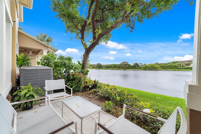 view of patio / terrace featuring central AC unit and a water view