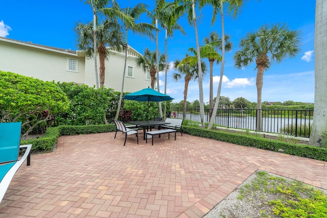 view of patio / terrace with outdoor dining area, a water view, and fence