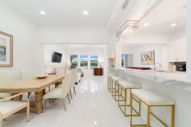 dining room featuring sink, a notable chandelier, and light tile patterned floors