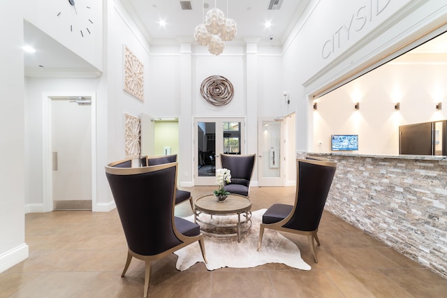 dining room with light tile patterned floors, visible vents, a towering ceiling, and crown molding