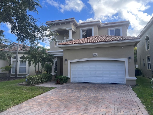 mediterranean / spanish house with a garage and a front yard