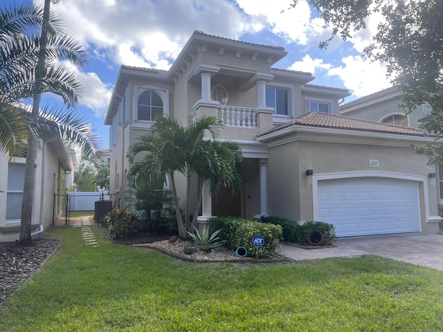 mediterranean / spanish house featuring a front yard, a balcony, and a garage