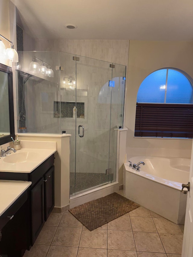 bathroom featuring shower with separate bathtub, vanity, and tile patterned floors