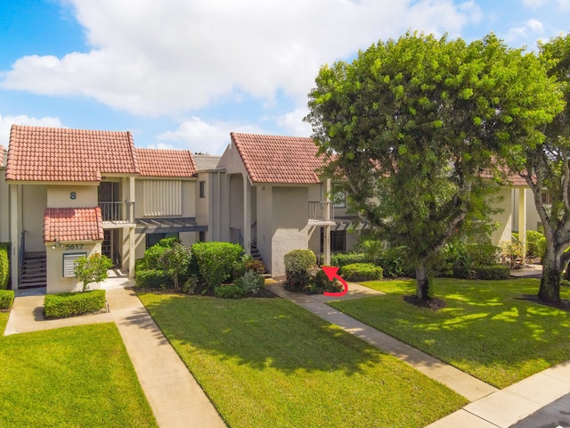 mediterranean / spanish-style house featuring a front yard