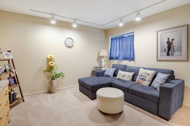 carpeted living room featuring rail lighting and a textured ceiling