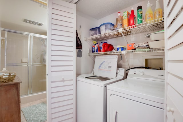 washroom with a textured ceiling, tile patterned floors, and washer and clothes dryer