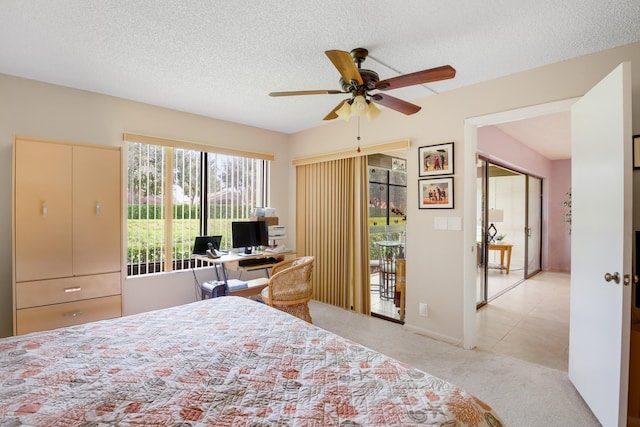 carpeted bedroom featuring access to exterior, a textured ceiling, and ceiling fan