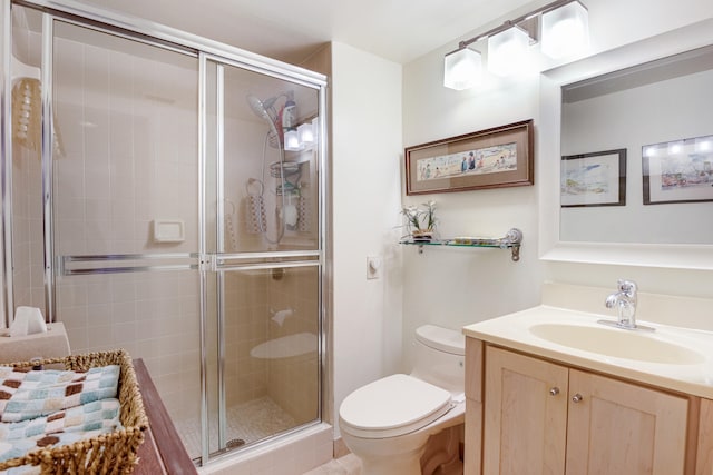 bathroom featuring vanity, toilet, and an enclosed shower