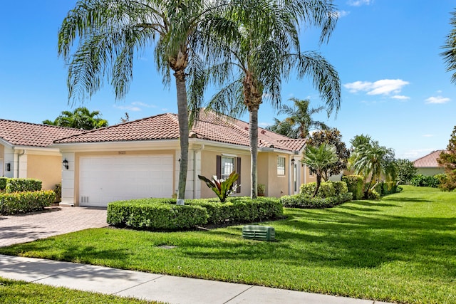 mediterranean / spanish-style home featuring a front yard and a garage